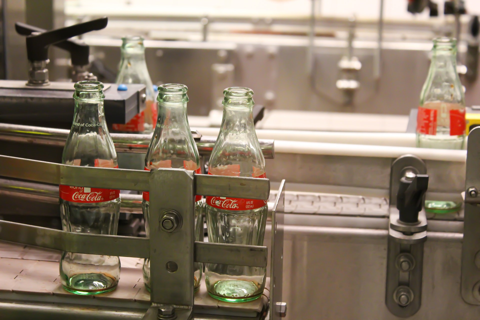 glass coca cola bottles on machine